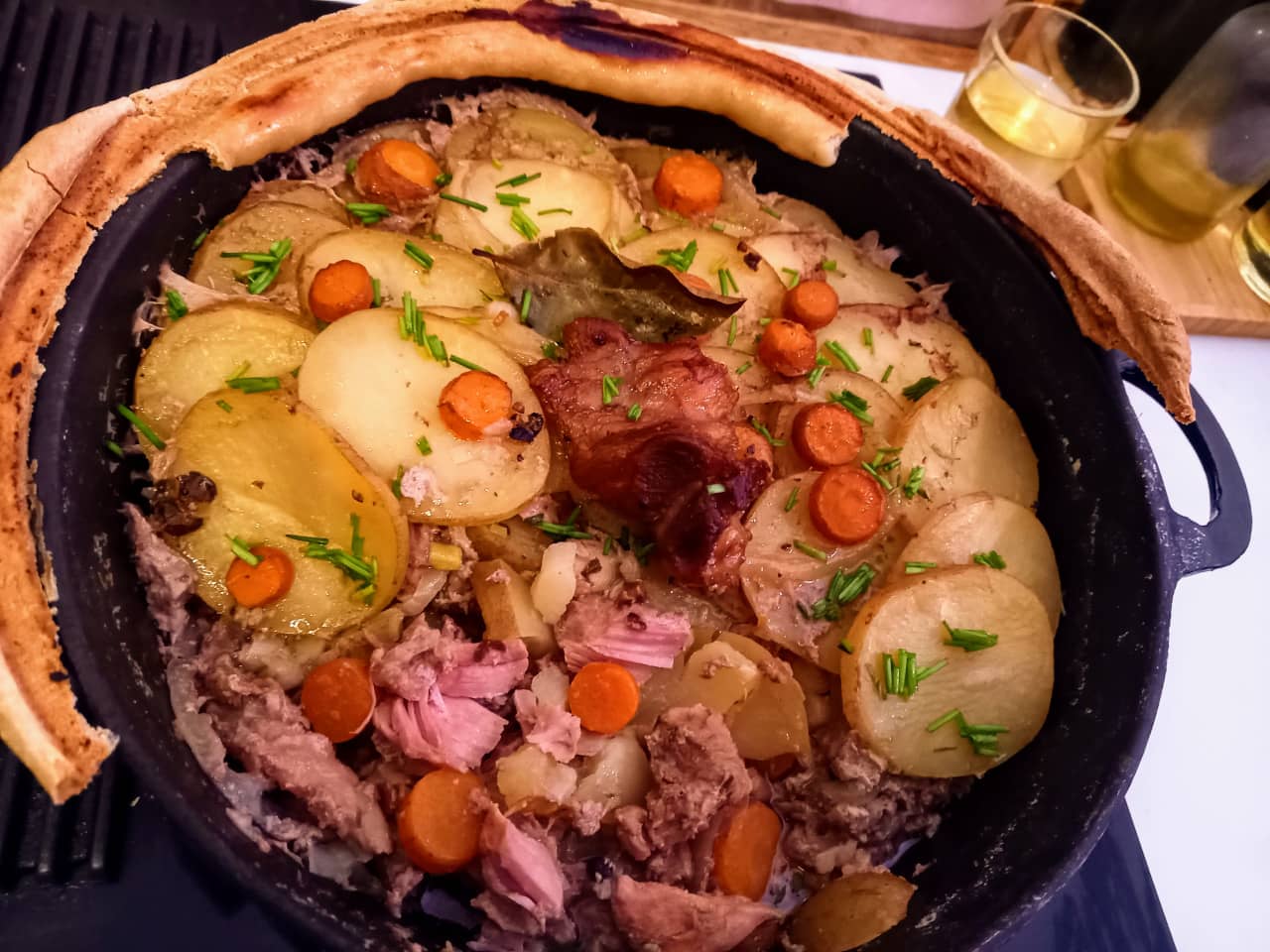 A cast iron pot filled with baekeoffe, on the rim you can see the dough used to seal the lid in the oven.