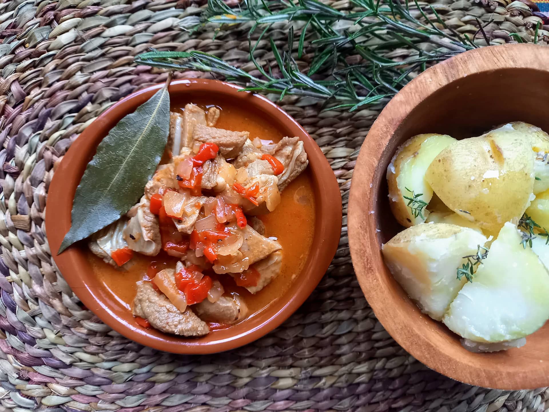 A small tapa with Caldereta de Cordero served next to some potatoes garnished with thyme.