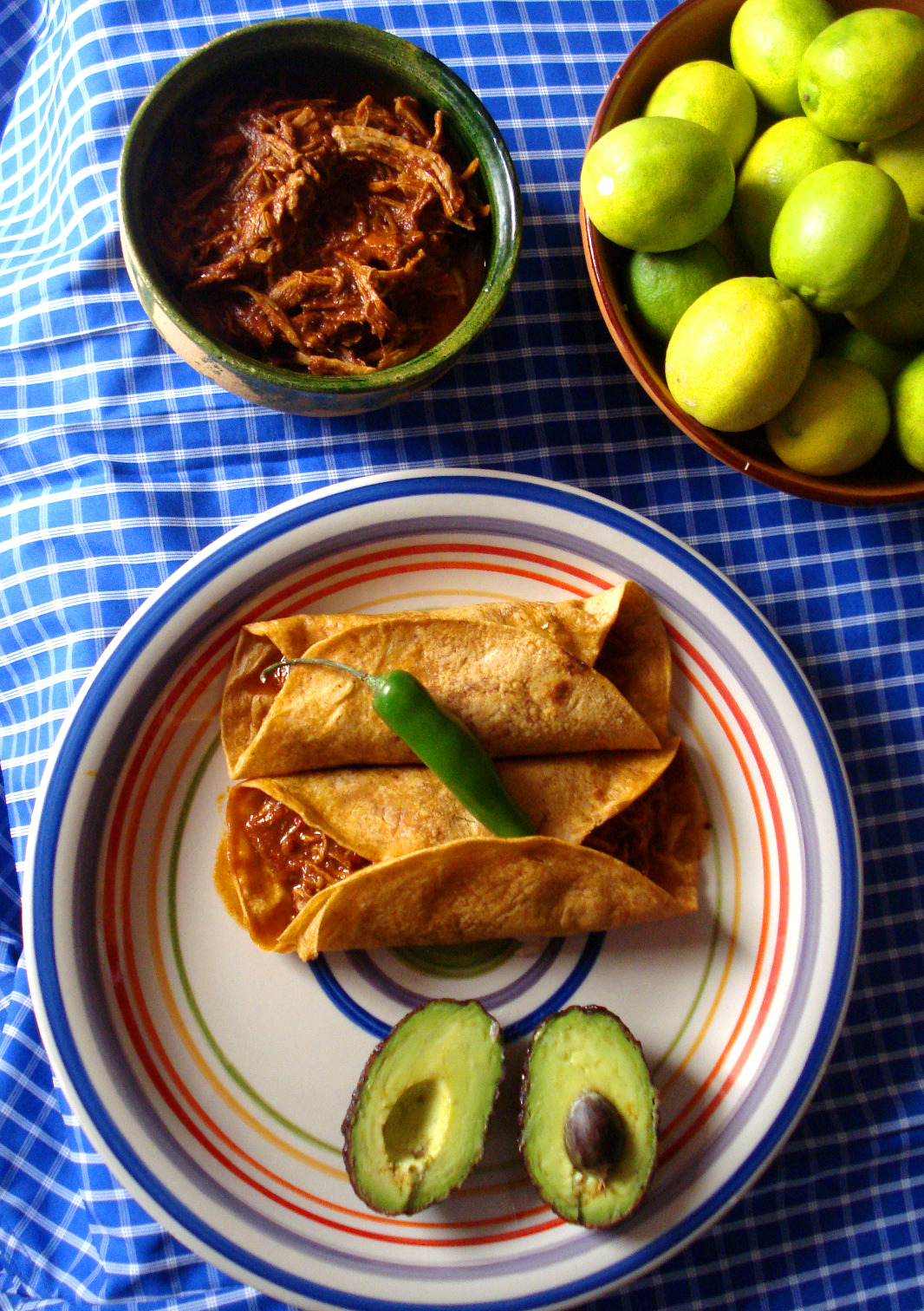 Two tortiallas with Chilorio crowned by a serrano pepper.