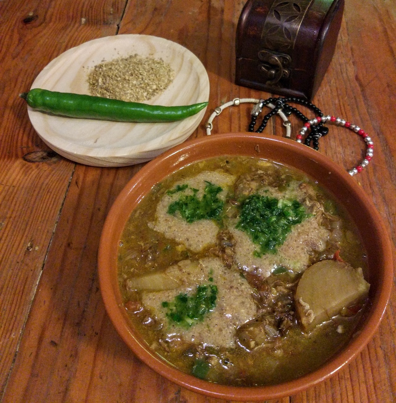 Fahsa Saltah stew in a bowl with a drop of hulba on top.